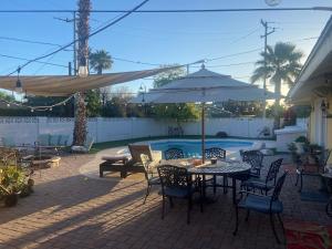 eine Terrasse mit einem Tisch, Stühlen und einem Sonnenschirm in der Unterkunft Windsor Room in Phoenix