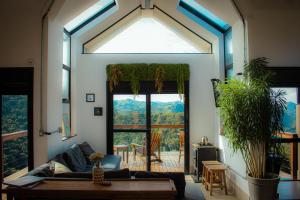 Una sala de estar con un sofá y una ventana grande. en Cabana na montanha com Ofurô ao ar livre, churrasqueira, trilha com cascata e Starlink, en Cambuí 87 fotos más