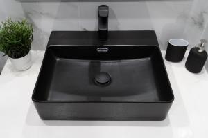a black sink on a counter with a plant at CozyLoft 2 in Patra