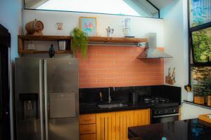 Una cocina con refrigerador de acero inoxidable y estufa. en Cabana na montanha com Ofurô ao ar livre, churrasqueira, trilha com cascata e Starlink, en Cambuí