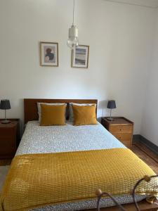sypialnia z łóżkiem z żółtą pościelą i poduszkami w obiekcie casa da vila w mieście Mora