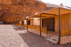 a row of buildings in front of a mountain at Solana Desert Camp in Wadi Rum