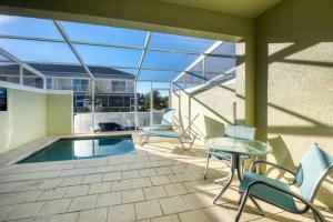 a patio with a table and chairs and a pool at Super cozy home with private pool in Orlando