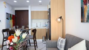 a living room with a couch and a table with flowers at Your Sleek Transit 1BR Oasis Hideaway in Abu Dhabi