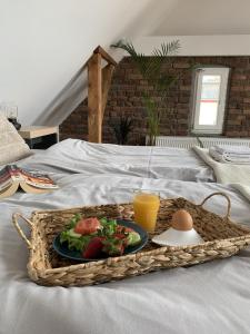 a tray with a plate of food and an egg on a bed at Apartamenty Astor - Księżycowy in Szczawno-Zdrój