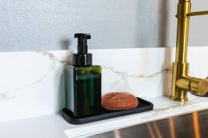 a bottle of soap sitting on a bathroom sink at Professionals-Restaurants-Fast-WiFi-A C-W D-Pets in San Diego