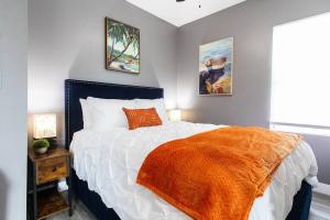 una camera da letto con un letto con una coperta arancione sopra di Studio - Balcony - A C - Dogs Parks Restaurants a San Diego