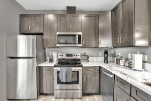 a kitchen with stainless steel appliances and wooden cabinets at Professionals-Restaurants-FastWiFi-A C-Desk- Pets in San Diego