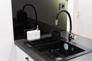 a kitchen counter with a sink and two faucets at CozyLoft 2 in Patra +18 photos