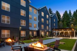 an exterior view of a building with fire pits at Homewood Suites Hillsboro Beaverton in Beaverton