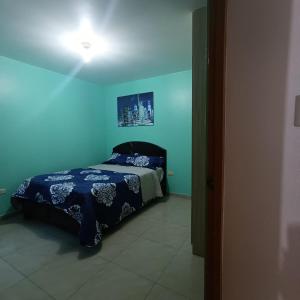 1 dormitorio con 1 cama en una habitación azul en Pablin, en Trujillo