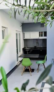 a living room with two green chairs and a table at Garden Rooms in Golem