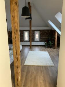 an attic room with a white rug and windows at Apartamenty Astor - Księżycowy in Szczawno-Zdrój