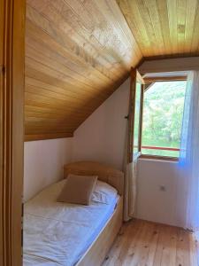 a small bed in a small room with a window at River View Tiny House with Garden in Šipovo
