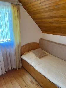 a small bedroom with a bed and a window at River View Tiny House with Garden in Šipovo