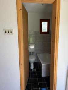 a bathroom with a toilet and a tub and a sink at River View Tiny House with Garden in Šipovo