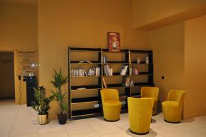 a room with yellow chairs and a book shelf at La Brasserie Hostel in Metz