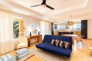 Il comprend un salon avec un canapé bleu et une cuisine. dans l'établissement 2-Bedroom Mountaintop Apartment with Incredible Ocean View, à Potrero