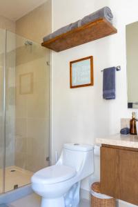 a bathroom with a toilet and a glass shower at Brand NEW! Tulum Jungle Villa with private pool in Tulum