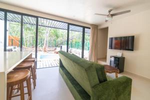 トゥルムにあるBrand NEW! Tulum Jungle Villa with private poolのリビングルーム(緑のソファ、バー付)