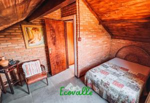 a bedroom with a bed and a table in a room at Ecovalle São Thomé in São Thomé das Letras