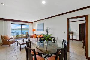 a living room with a table and a couch at Remodeled Top-Floor Flamingo Condo with Outstanding Ocean Views in Playa Flamingo
