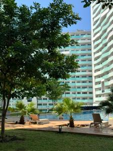 einen Park mit Stühlen und Bäumen vor einem Gebäude in der Unterkunft Nice one BR condo free pool in Commonwealth QC in Manila
