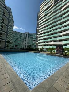 ein großer Pool mit Gebäuden im Hintergrund in der Unterkunft Nice one BR condo free pool in Commonwealth QC in Manila