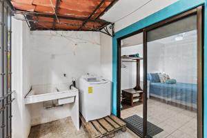 Habitación con baño con lavabo y nevera. en Bright and Spacious Loft-Style Apartment a Five-Minute Walk to the Beach, en Coco 11 fotos más