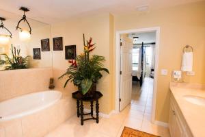 baño con bañera y una planta sobre una mesa en Classy artsy ocean-view unit near pool at Pacifico in Coco sleeps 6, en Coco