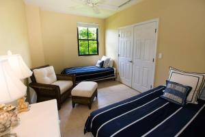 Zimmer mit einem Bett, einem Stuhl und einem Fenster in der Unterkunft Classy artsy ocean-view unit near pool at Pacifico in Coco sleeps 6 in Coco