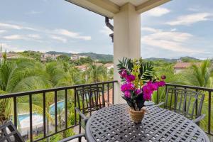 una mesa con un jarrón de flores en el balcón en 3-Bedroom 2-Bath Condo Overlooking Pool en Coco