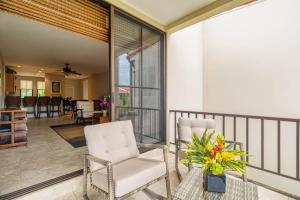 a living room with two white chairs on a balcony at 3-Bedroom 2-Bath Condo Overlooking Pool in Coco