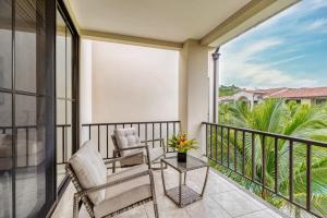 a balcony with two chairs and a table at 3-Bedroom 2-Bath Condo Overlooking Pool in Coco