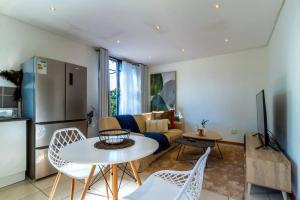 uma sala de estar com um sofá e uma mesa em 1 Bedroom Apartment in Houghton with Uninterrupted WiFi em Joanesburgo