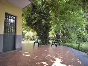 two benches sitting on a patio under a tree at Villa Anna in Mascali