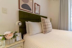 um quarto com uma cama com uma cabeceira verde em 1 Bedroom Apartment in Houghton with Uninterrupted WiFi em Joanesburgo