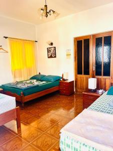 a bedroom with two beds and a green bed at Casa BB&Djassi in Ponta do Sol