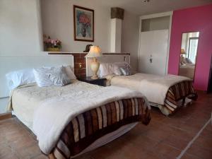 1 dormitorio con 2 camas y una lámpara en una mesa en SOLACHE INN, en Zitácuaro