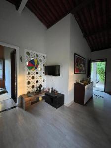 a living room with a couch and a tv at Granja Raio de Luz in Igarassu