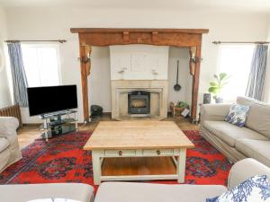 a living room with a couch and a fireplace at Wig Carna in Holyhead