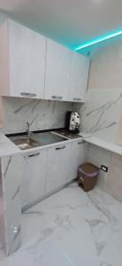 una cocina con encimeras de mármol blanco y fregadero en La casetta di Totò, en Nápoles