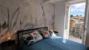 a bedroom with a bed with a blue bedspread and a window at Arbanella in Corniglia