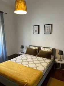 a bedroom with a bed and two tables with lamps at casa da vila in Mora