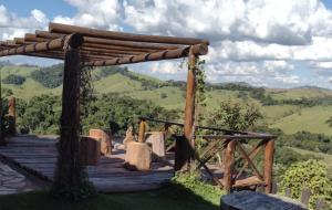 a wooden deck with a view of the mountains at Ecovalle São Thomé in São Thomé das Letras