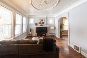 a living room with a couch and a fireplace at Stylish 2-Story Home with Workspace in Detroit