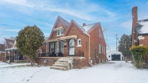 une maison en briques avec de la neige au sol dans l'établissement Stylish 2-Story Home with Workspace, à Detroit