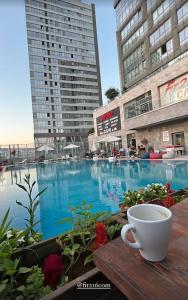 a cup of coffee sitting on a table next to a swimming pool at Kendi evinizdeymiş gibi konaklama fırsatı.TÜM EV in Istanbul