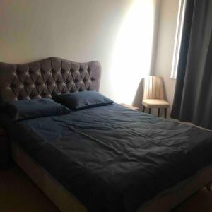 a bed with a blue comforter and blue pillows at Kendi evinizdeymiş gibi konaklama fırsatı.TÜM EV in Istanbul