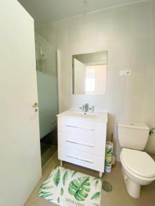 ein Badezimmer mit Toilette, Waschbecken und Spiegel in der Unterkunft Lovely two bedroom Pool & Golf Apartment - SA928LTZ in Roldán